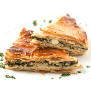 ciasto spanakopita pocięte w dwa trójkąty, z przypieczoną skórką